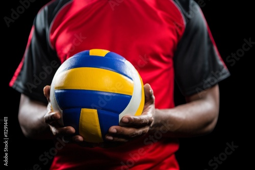 Mid-section of sportsman holding a volleyball