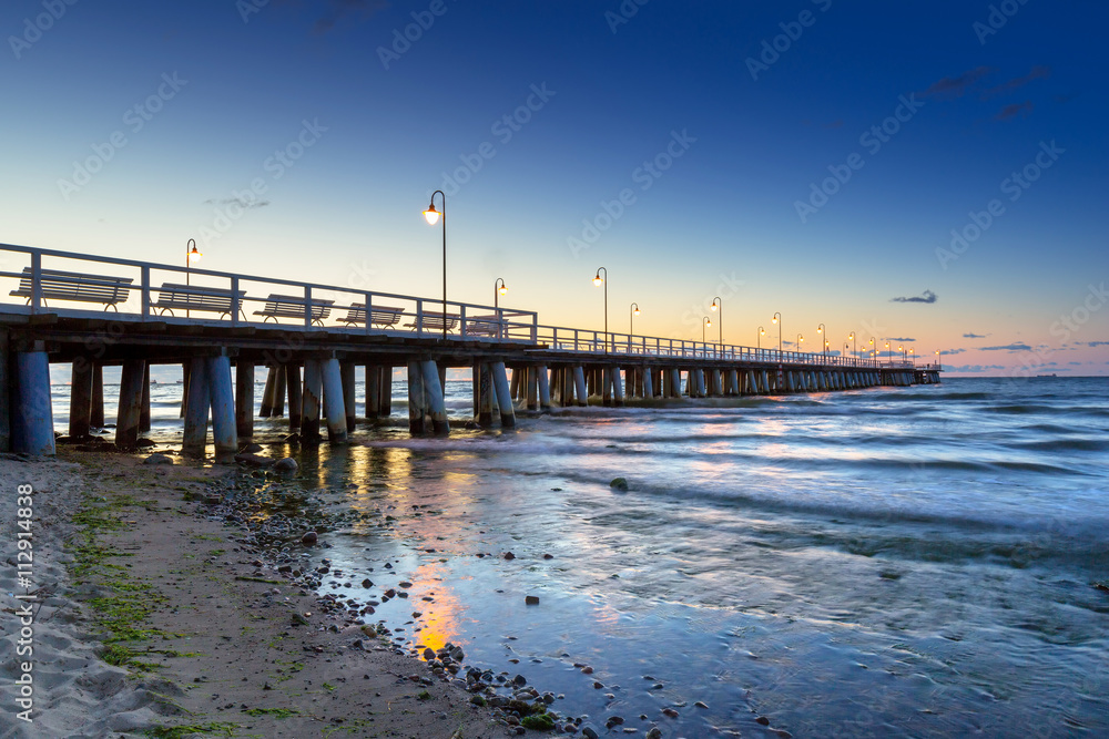 Baltic sea with pier in Gdynia Orlowo at sunrise, Poland