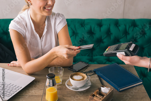 Woman pay with credit card in cafe bar