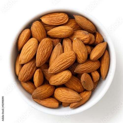 Bowl of whole almonds isolated on white from above. photo