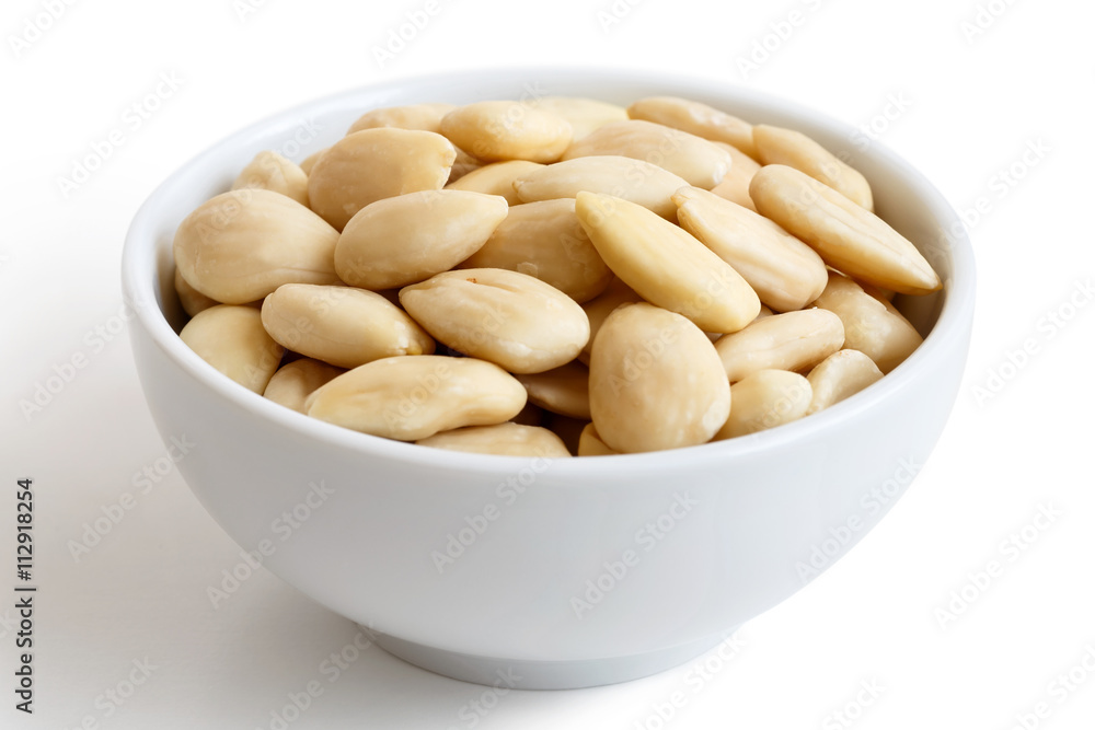 White bowl of peeled whole almonds isolated on white. White bowl of peeled whole almonds isolated on white.