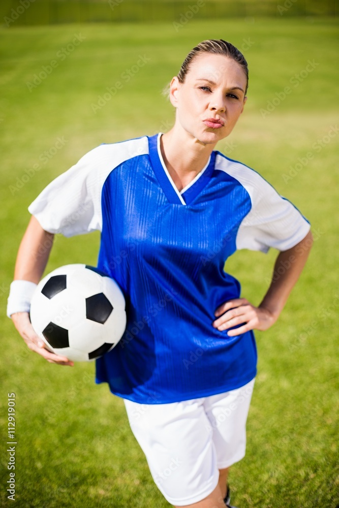 Female football player standing with a ball Female football player standing with a ball