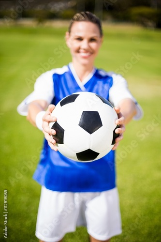 Female football player standing with ball © WavebreakMediaMicro