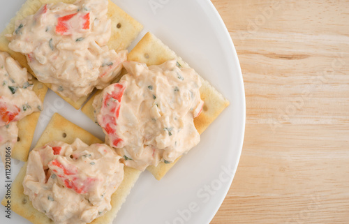 Φωτογραφία Plate of lobster dip on saltine crackers atop wood table