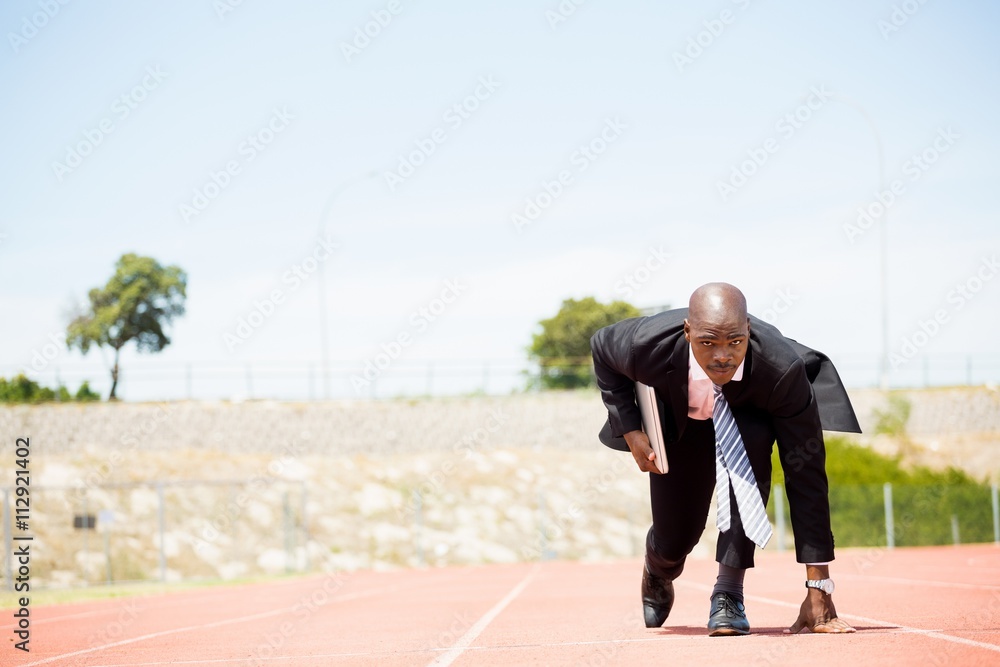 Businessman with laptop ready to run Businessman with laptop ready to run