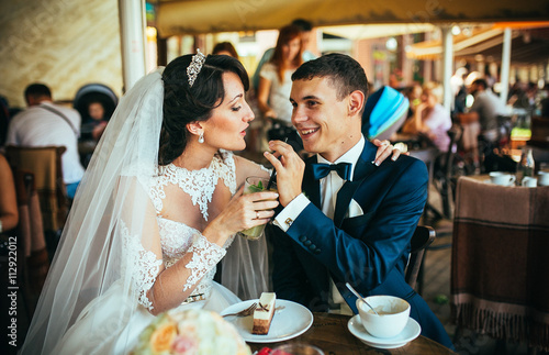 Bride and groom drinking coffee at an outdoor cafe
