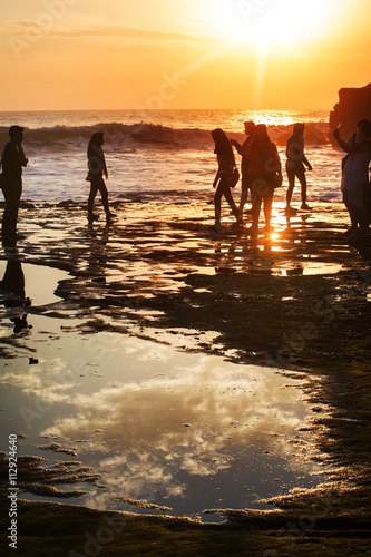 People silhouette on sunrise in the sea with soft wave and cloudy