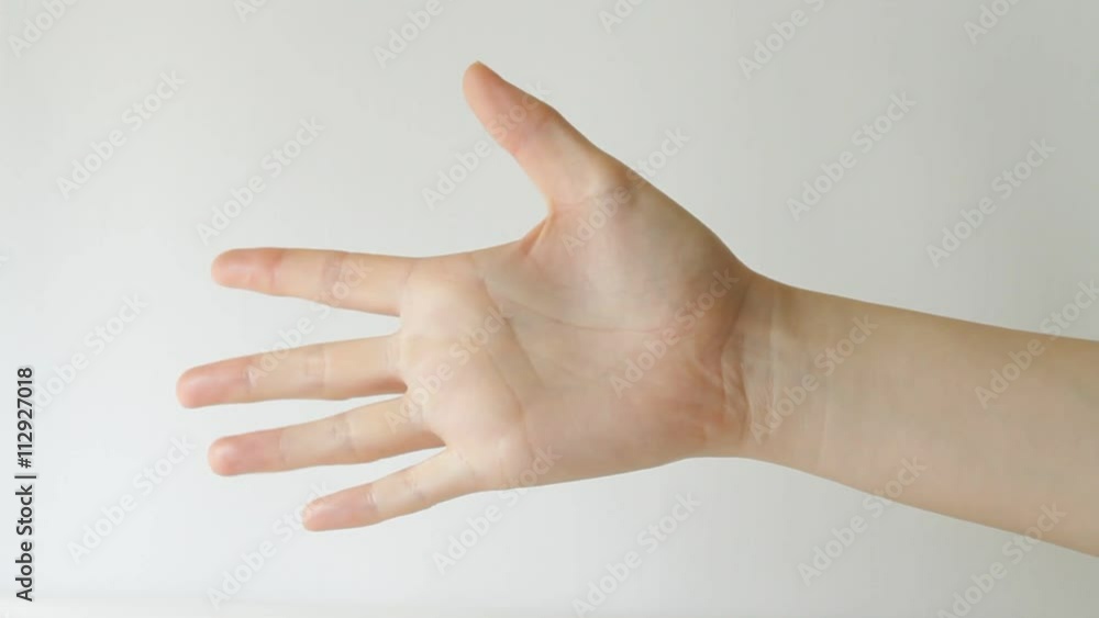 Woman's hand doing game rock paper scissors against white background Woman's hand doing game rock paper scissors against white background
