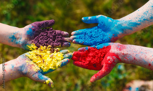 Hands / Palms of young people covered in purple, yellow, red, bl