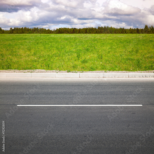 Empty highway roadside with green grass photo