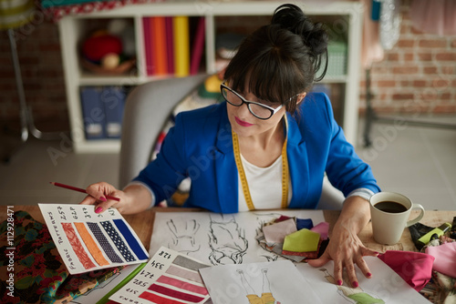 Female designer looking at color swatch photo