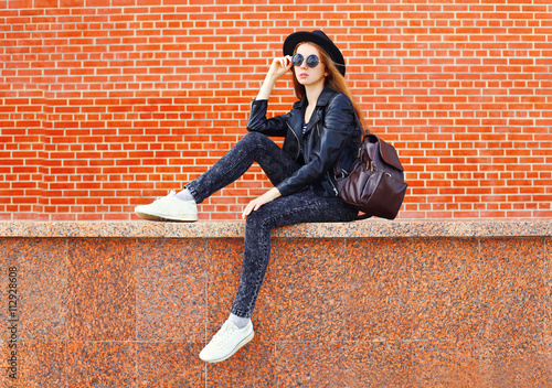 Fashion pretty woman in black rock style sitting in city over br © rohappy