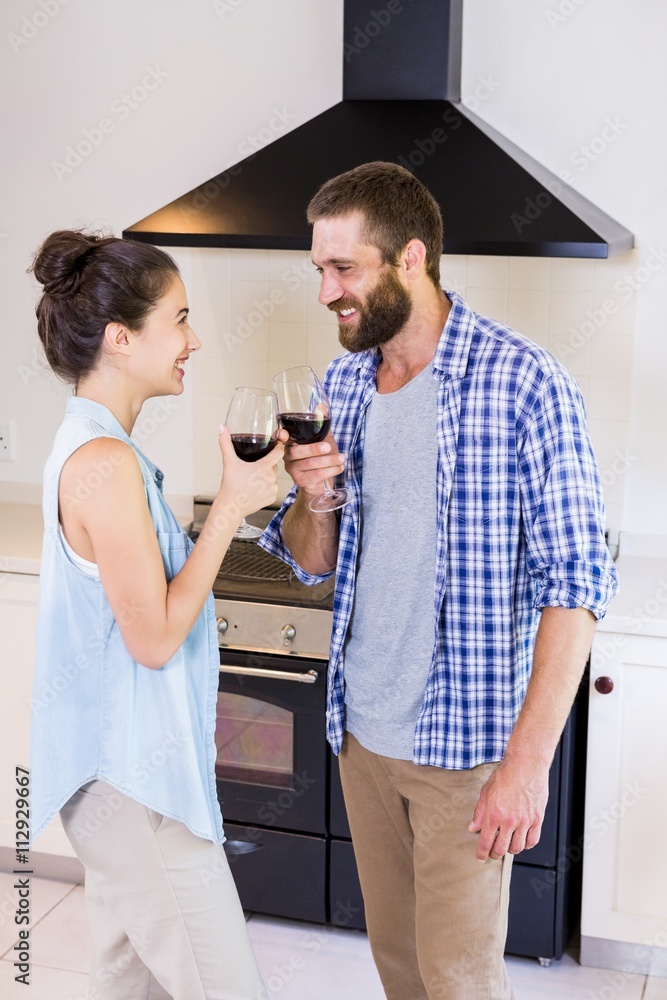 Young couple toasting wine glass in kitchen Young couple toasting wine glass in kitchen