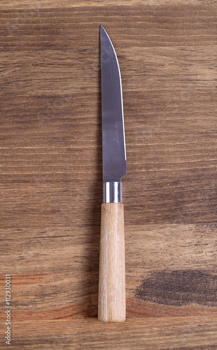 Knife with wooden handle on brown wooden table