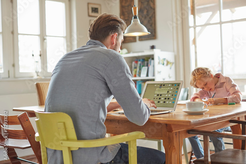 Father and son working in home office