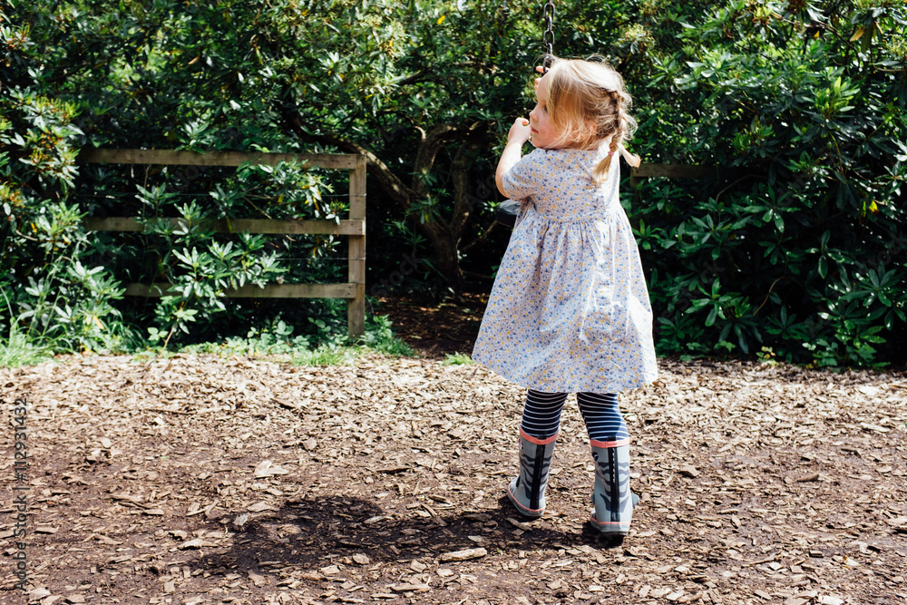 Young blonde girl holding zip wire, rear view Young blonde girl holding zip wire, rear view