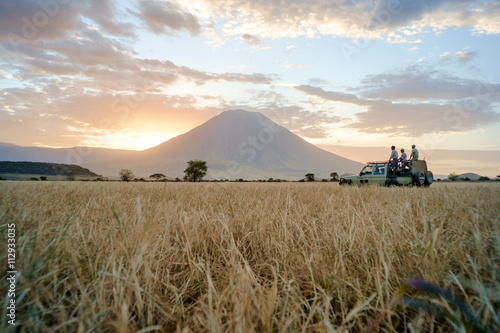 People on safari in savannah landscape during sunset, Africa