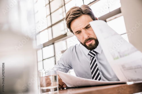 Bearded businessman looking down at paperwork photo