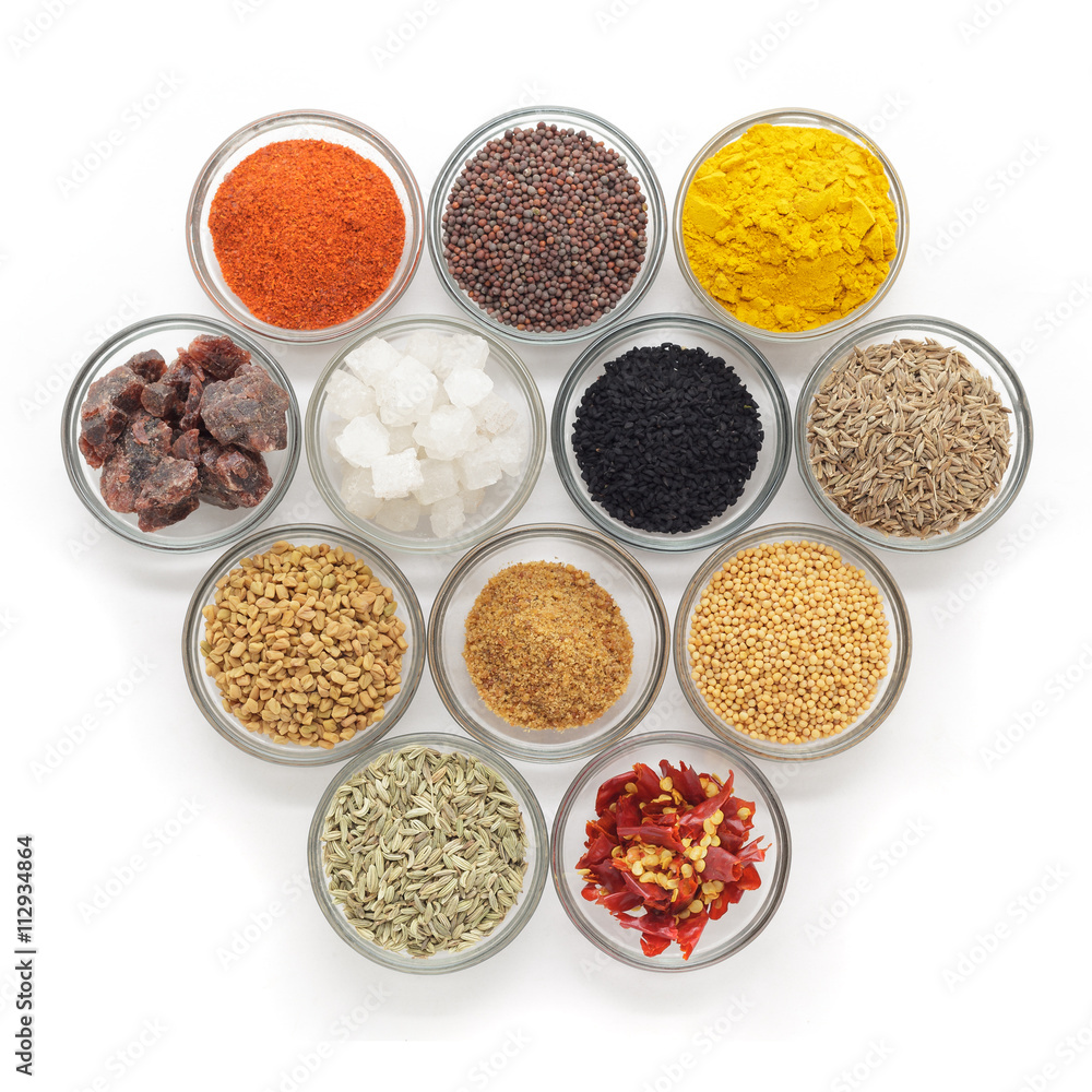 Different types of Indian spices in glass bowls isolated on white background. Top view.