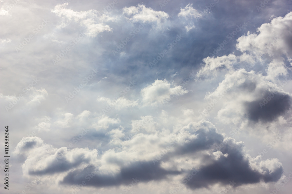 Fototapeta premium Fluffy clouds backlit scenery.