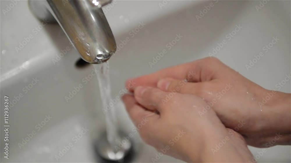 Woman washes her hands with soap in the bathroom, close-up Woman washes her hands with soap in the bathroom, close-up