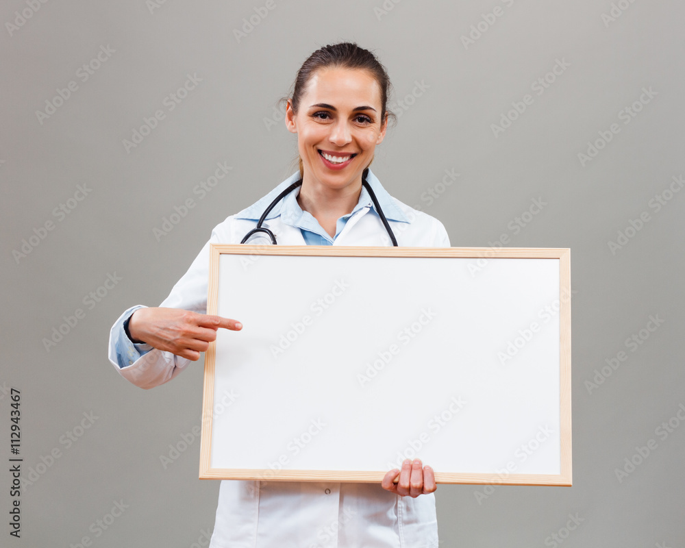 Beautiful female doctor pointing at whiteboard . Beautiful female doctor pointing at whiteboard .