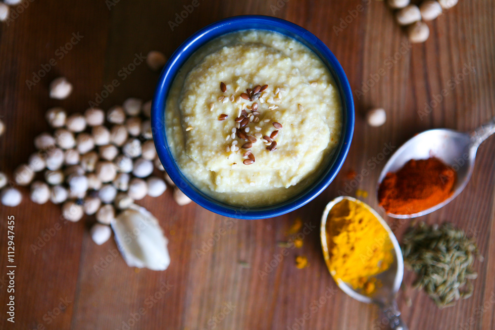 Hummus, chickpea dip, with rosemary, smoked paprika and olive oil in an authentic bowl with pita on a wooden background. Hummus, chickpea dip, with rosemary, smoked paprika and olive oil in an authentic bowl with pita on a wooden background.