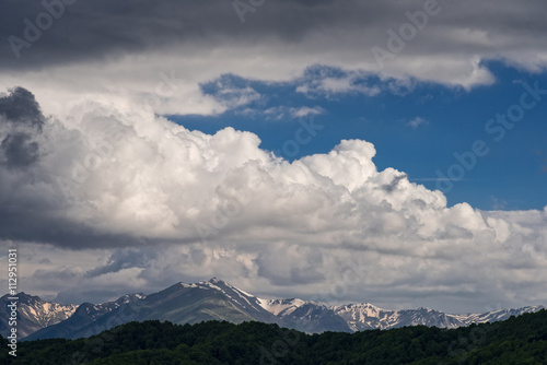 Mountain ridge with snow and blue sky with spectacular clouds in Epirus, Greece