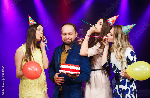 Happy birthday! Group of smiling friends gathered together with photo