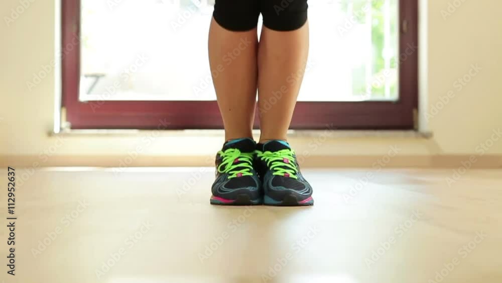 Girl jumping on a skipping rope on the floor, close up, slow motion
Girl jumping on a skipping rope on the floor, close up, slow motion