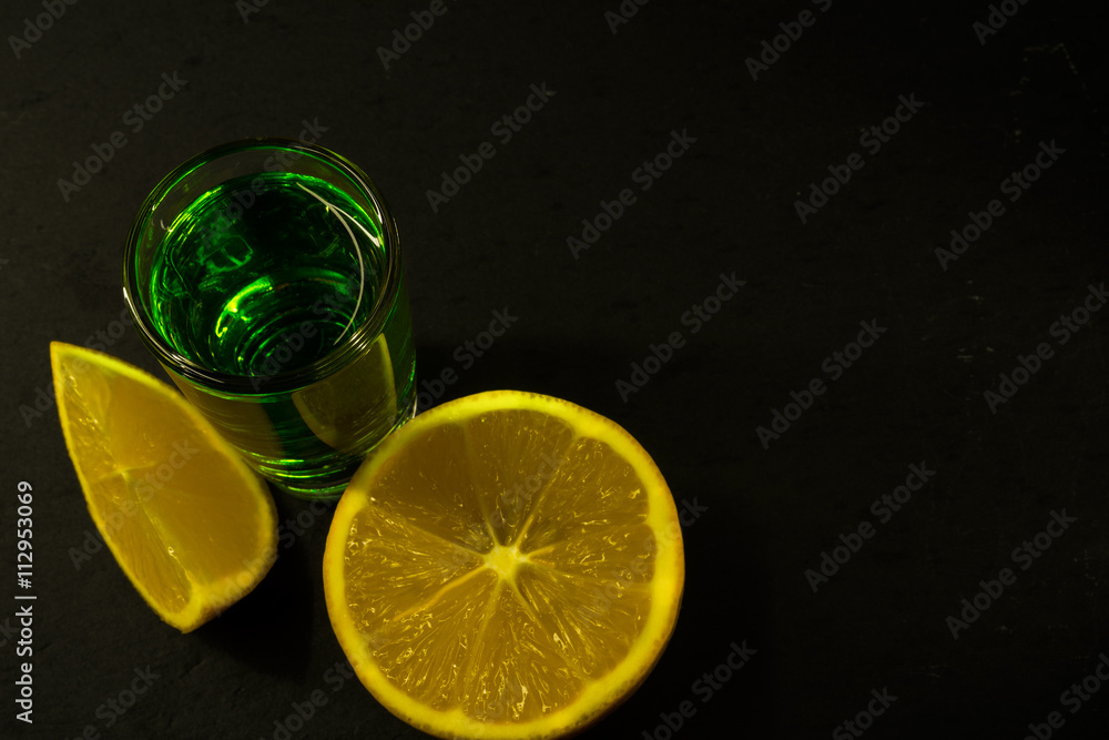 Absinthe and lemon on black background Absinthe and lemon on black background