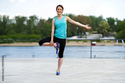 Fit woman streching in part after run. © Wisiel