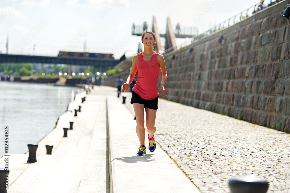 Fit woman jogging by the river.