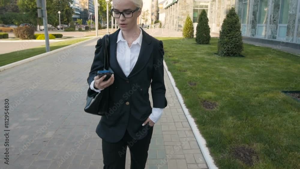 Business Woman Walking And Making a Phone Call Outdoor In City. Business Woman Walking And Making a Phone Call Outdoor In City.