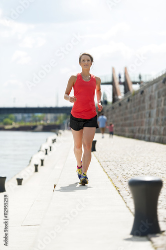 Fit woman jogging by the river.