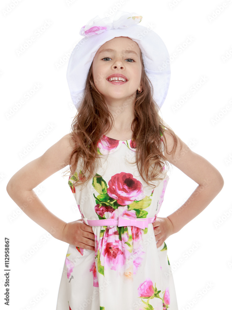 Beautiful little girl in a white summer dress with large rose in white cap posing in front of the camera . close-up - Isolated on white background Beautiful little girl in a white summer dress with large rose in white cap posing in front of the camera . close-up - Isolated on white background