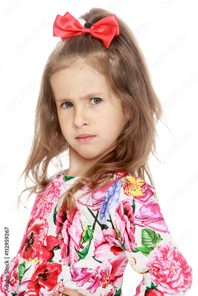 Frowning a little girl with a red bow on his head. Close-up - Isolated on white background Frowning a little girl with a red bow on his head. Close-up - Isolated on white background