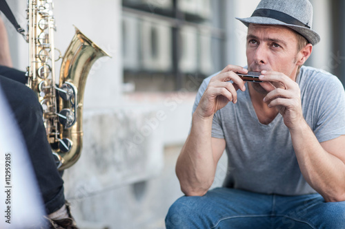 Street musician playing harmonica photo
