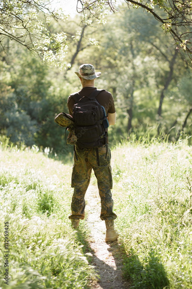 Male tourist standing in forest. Back view.