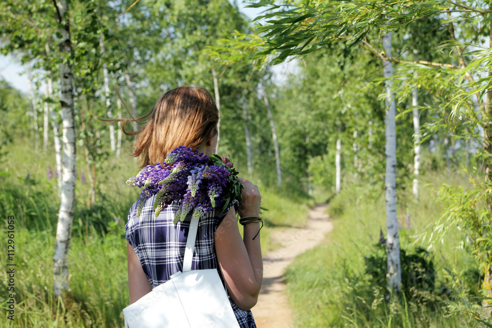 outdoor recreation / girl in a summer dress walking with a bouquet flowers on the forest path outdoor recreation / girl in a summer dress walking with a bouquet flowers on the forest path