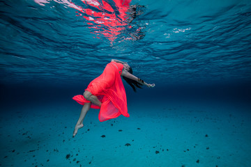 Woman underwater in red dress
