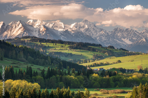 Beautiful spring panorama of Tatra mountains and green hills