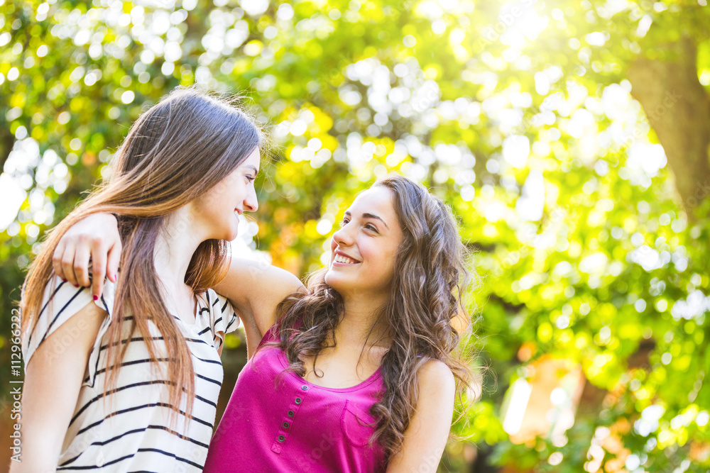 Two girls embraced together at park Two girls embraced together at park