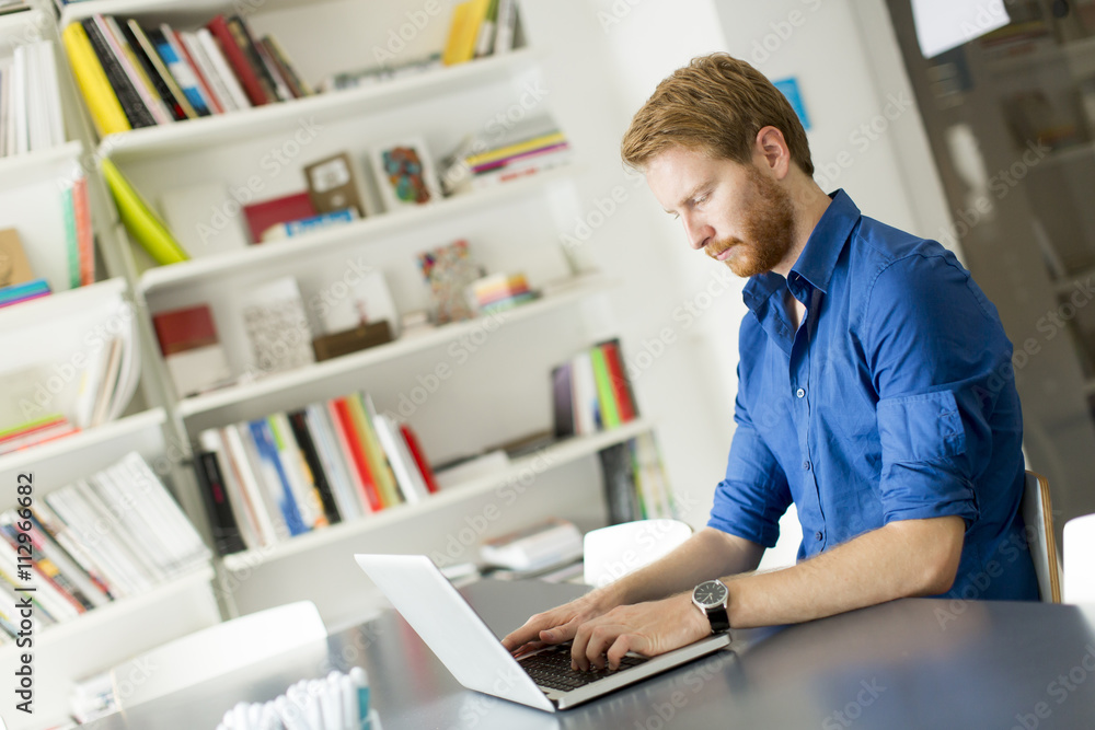 Young redhair man working on  computer