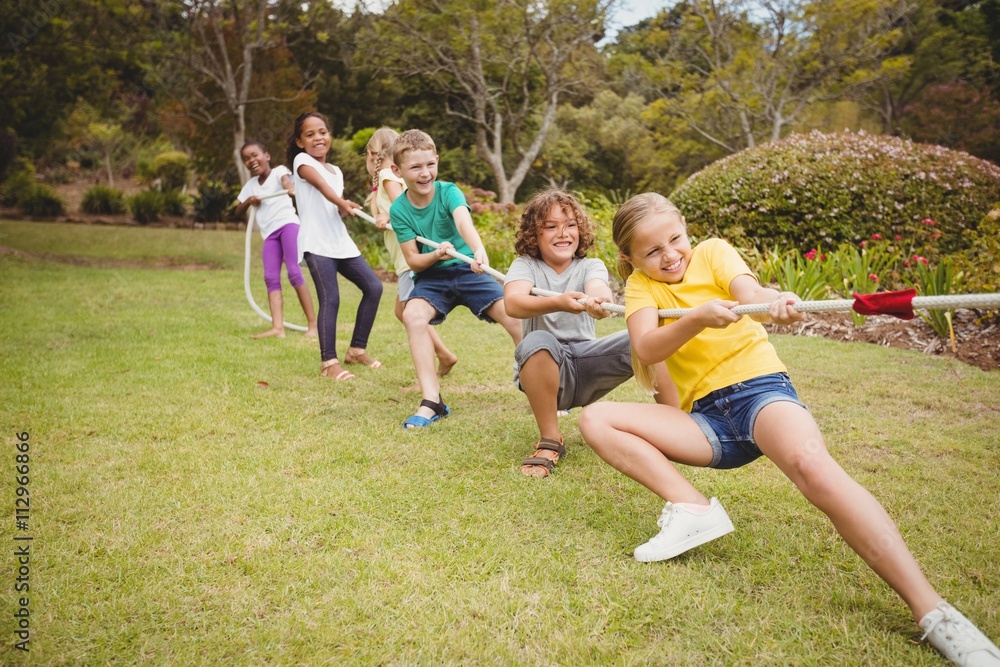 Children pulling a rope in tug of war Stock Photo | Adobe Stock