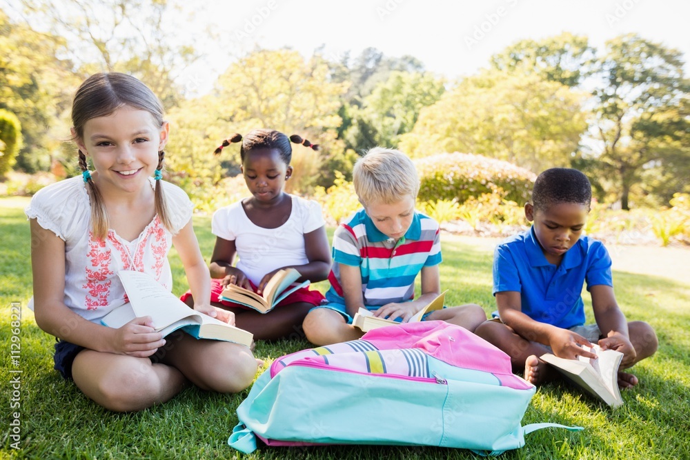 Kids reading books during a sunny day Kids reading books during a sunny day