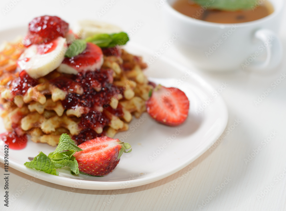 belgium waffles with strawberries, mint and raspberry jam