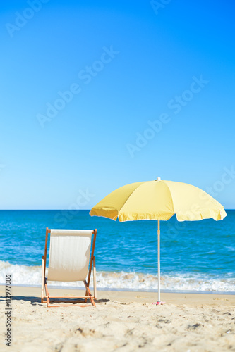 Yellow umbrella and wooden chair on Atlantic sandy beach © aquar