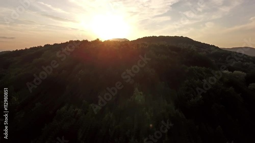Flying over rural hills into the sunset