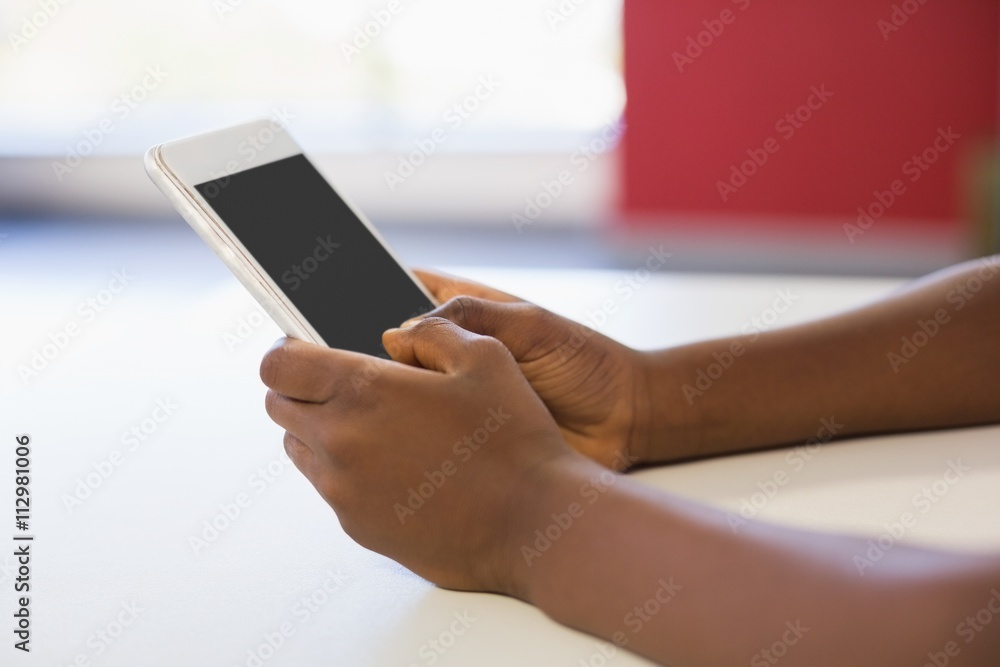 Schoolgirl using mobile phone in classroom